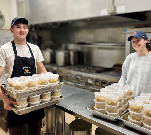 kitchen workers carrying trays of food
