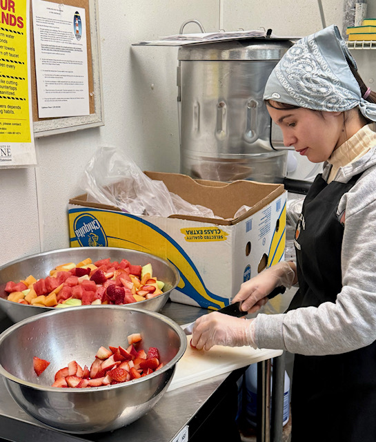 Young Lady cutting fruit in commercial kitchn
